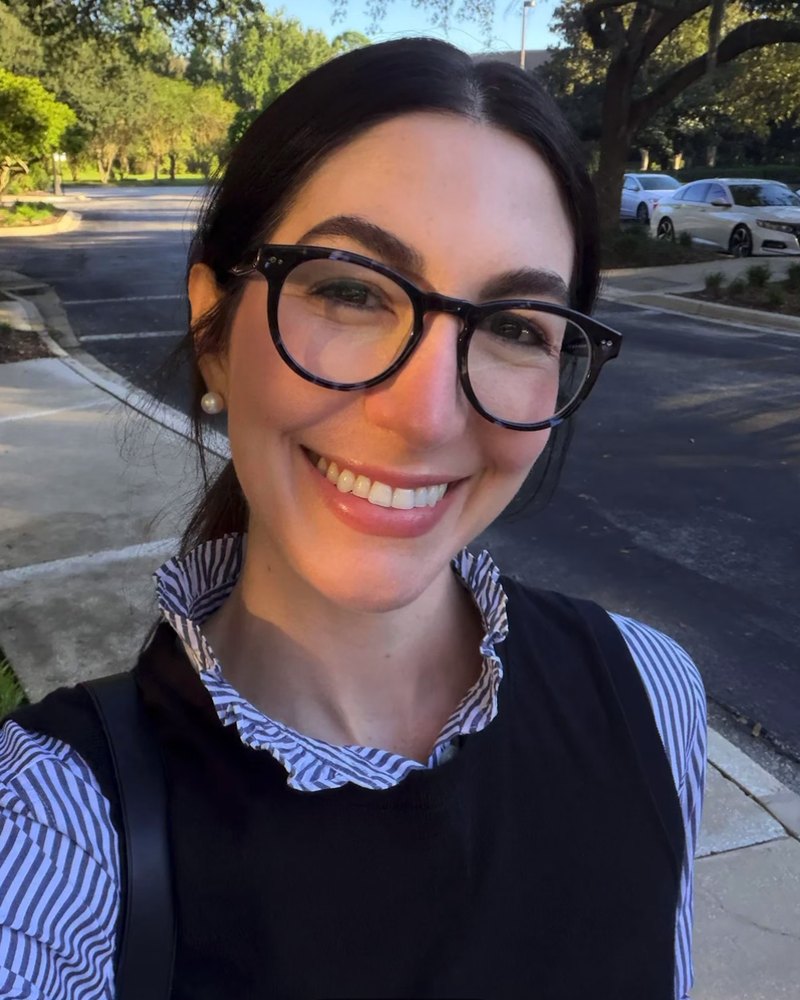 Reddit poster smiling outdoors in round black glasses