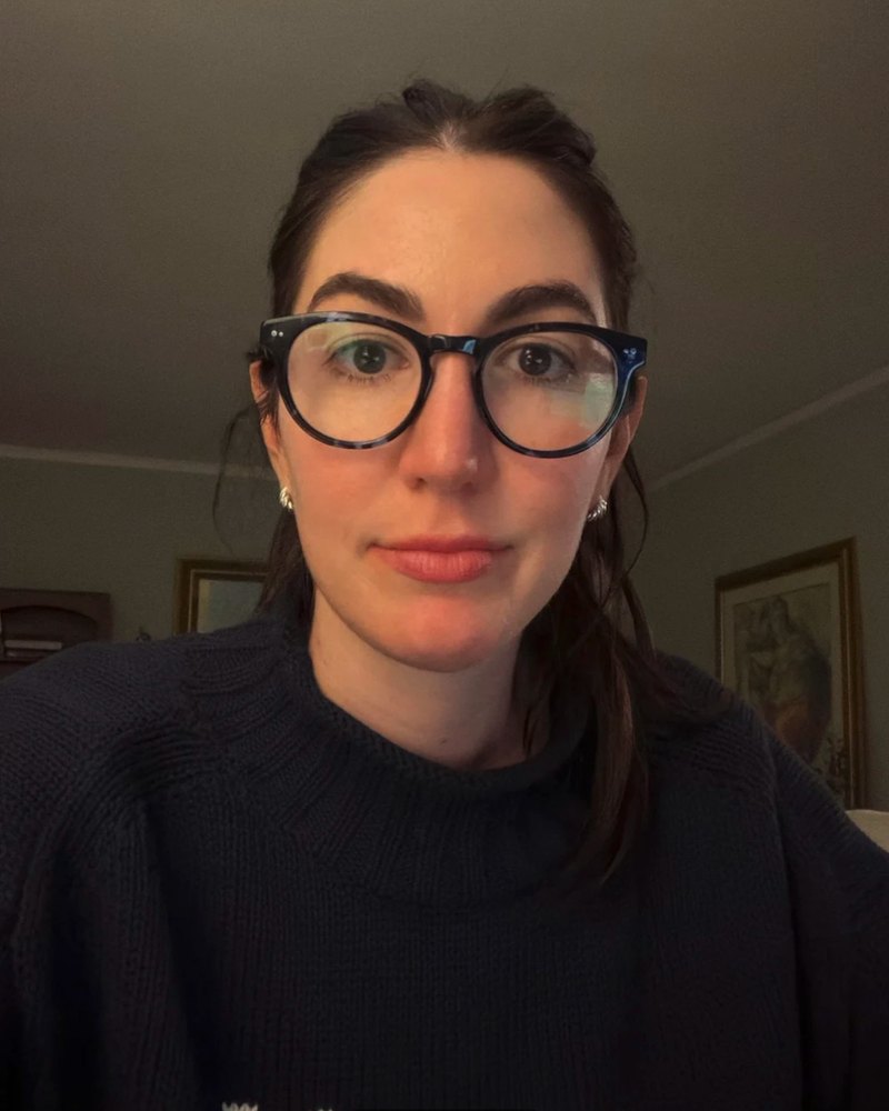 Poster facing the camera in round black glasses with a straight top line
